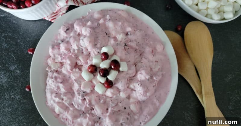 Quick and Easy Cranberry Fluff Salad 11 cranberry fluff salad in a white bowl with wooden spoons