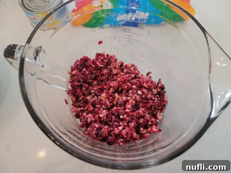 Quick and Easy Cranberry Fluff Salad 5 shredded cranberries in a glass bowl for cranberry fluff salad