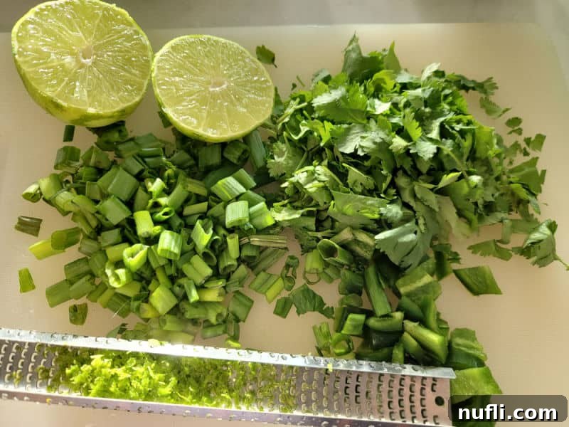 lime, chopped green onion, chopped cilantro, and lime zest on a cutting board for Cranberry Salsa