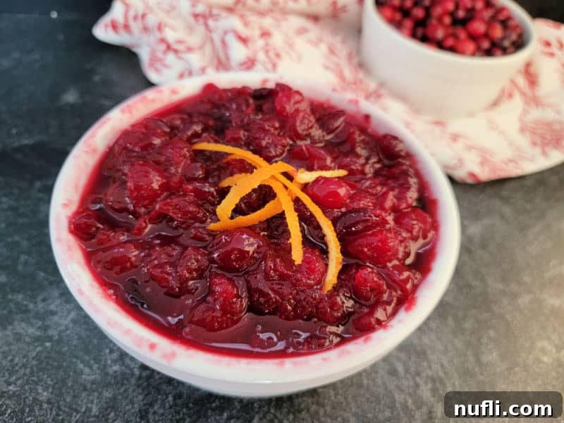 Easy cranberry sauce in a white bowl with orange strips