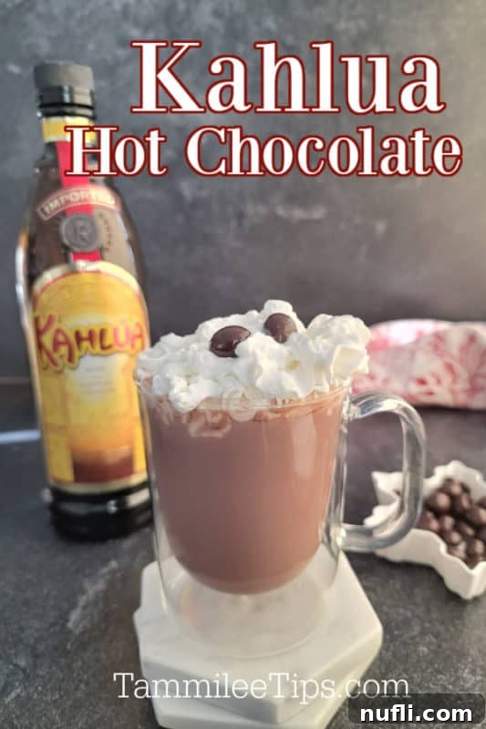 Decadent Kahlua Hot Chocolate 2 A steaming glass mug of Kahlúa Hot Chocolate, topped with fluffy whipped cream and two decadent chocolate-covered coffee beans, set against a cozy, festive backdrop.