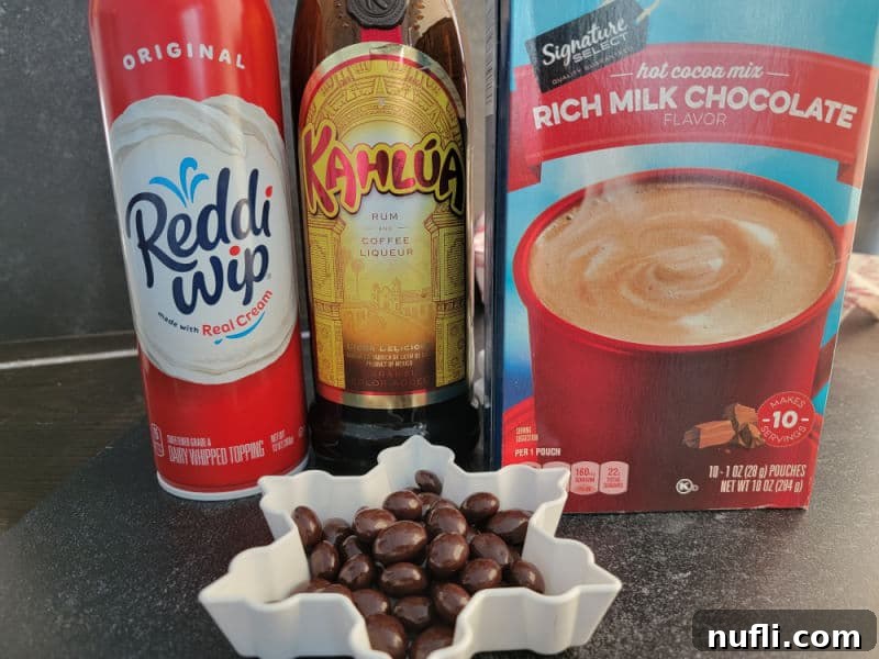 Decadent Kahlua Hot Chocolate 3 Ingredients for Kahlúa Hot Chocolate displayed: a bottle of Kahlúa Rum and Coffee Liqueur, a carton of milk, a mug of hot chocolate mix, a can of whipped cream, and chocolate-covered espresso beans.