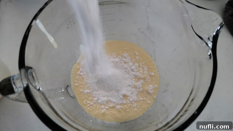 dry vanilla pudding pouring into a glass bowl with eggnog for eggnog pie