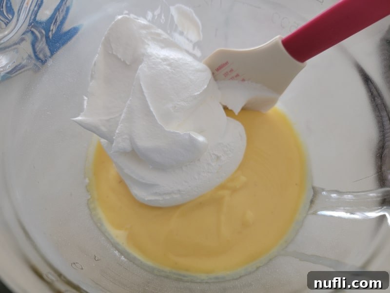 Cool whip on top of eggnog pie mixture in a glass bowl