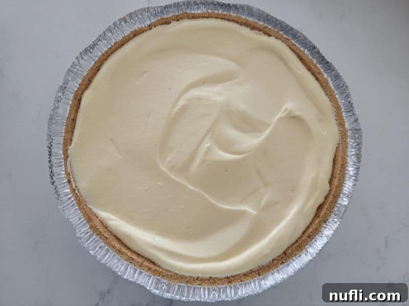 No bake eggnog pie in a graham cracker shell on a white counter