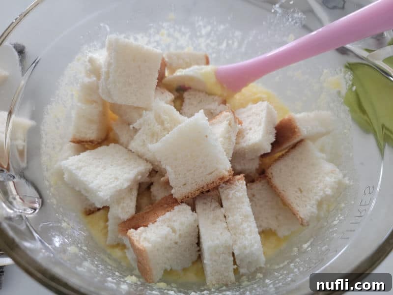 Effortless 5 Ingredient Pineapple Stuffing 7 white bread in a glass bowl with butter mixture for pineapple stuffing.