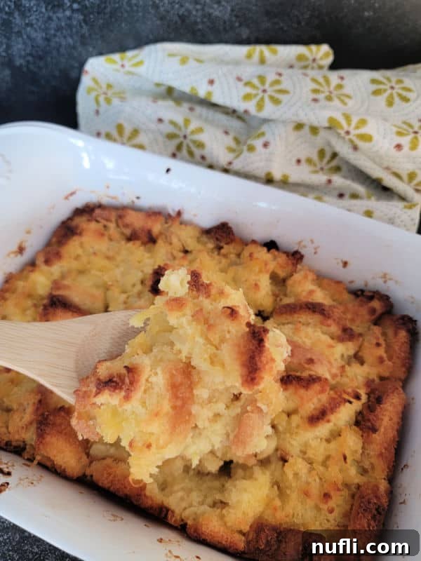 Effortless 5 Ingredient Pineapple Stuffing 10 Wooden spoon serving pineapple stuffing from a white baking dish