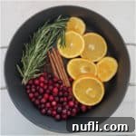 pot filled with Christmas potpourri cranberries, orange slices, cinnamon, cloves and more