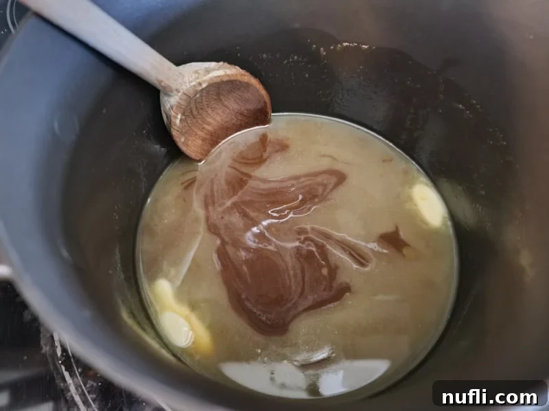 Irresistible 4 Ingredient Christmas Crack 6 Saucepan with butter and brown sugar to make toffee for Christmas Crack