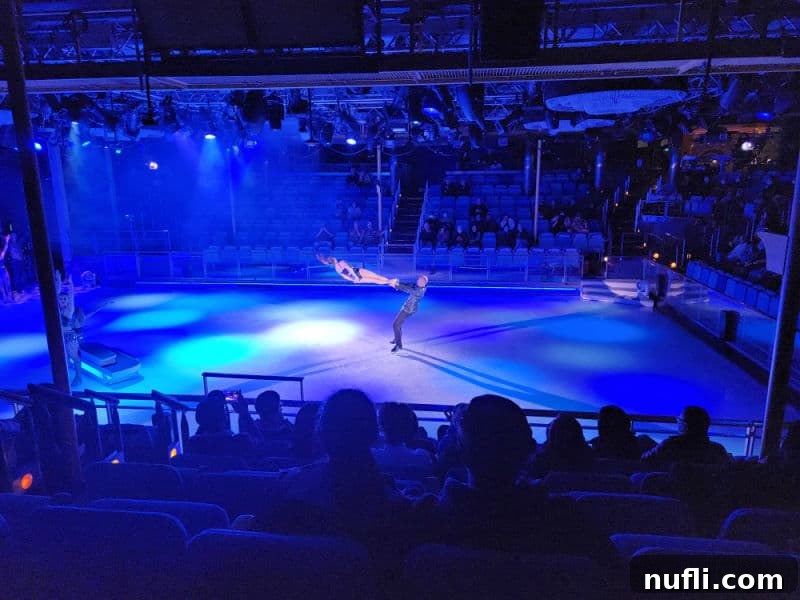 ice skater being spun in the air while on an ice rink with blue lights