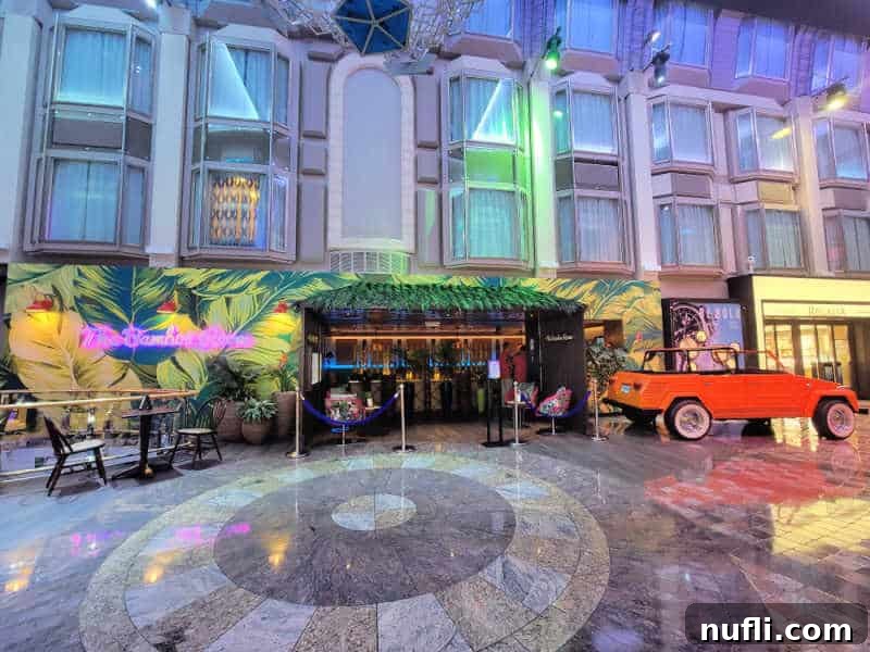 Tropical bar entrance with palm fronds on the wall and a historic open top Jeep