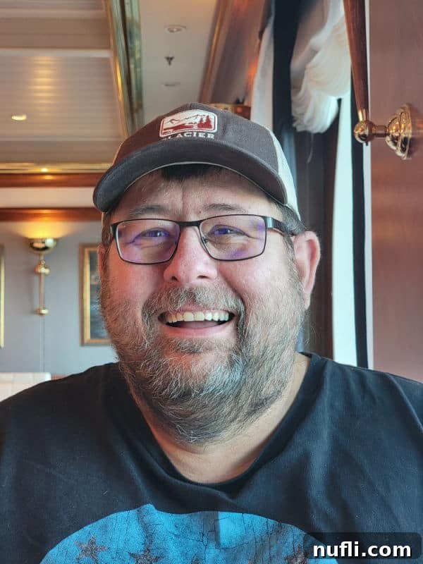 John smiling wearing a Glacier hat