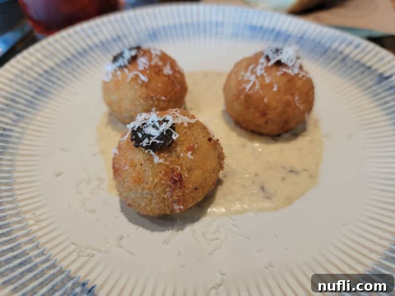 rice balls on a white plate with sauce