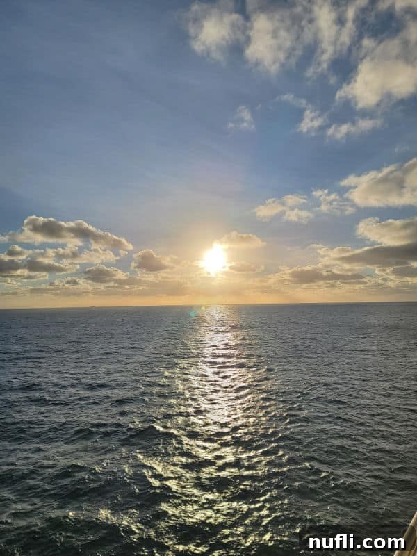 Sunset over the ocean with fluffy white clouds