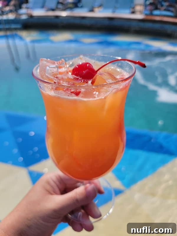 Sip Smart: Your Ultimate Royal Caribbean Drink Package Strategy 3 Tropical cocktail being held near a pool on a Royal Caribbean cruise ship with blue skies
