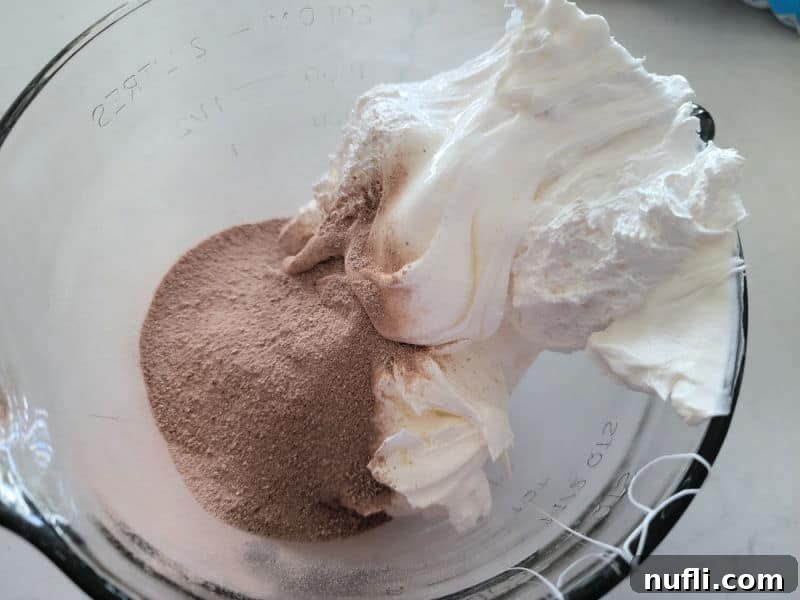 Hot Chocolate dip ingredients in a clear glass bowl before mixing