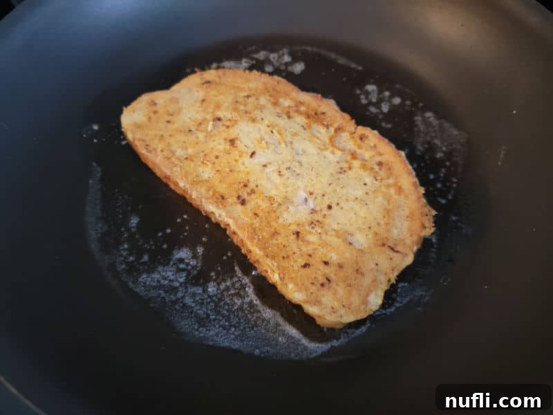 Effortless Eggnog French Toast 7 Eggnog French Toast cooking in a pan