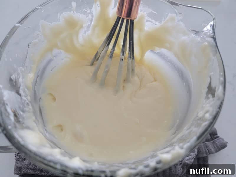 Eggnog glaze being whisked together in a clear glass bowl
