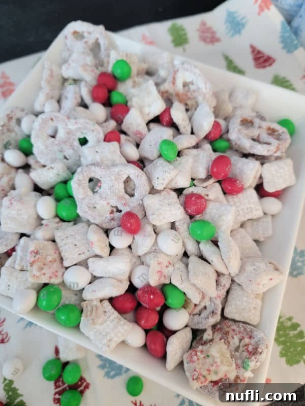 Reindeer chow with m&m in a white bowl on a holiday napkin