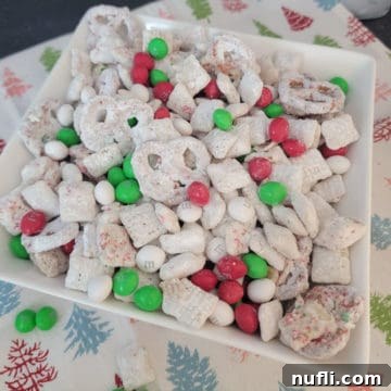 Christmas Reindeer Chow in a white bowl with a holiday cloth napkin