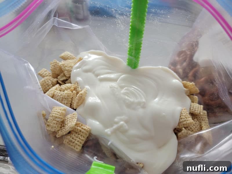 Vanilla Almond bark poured over Chex cereal for Reindeer Chow Recipe