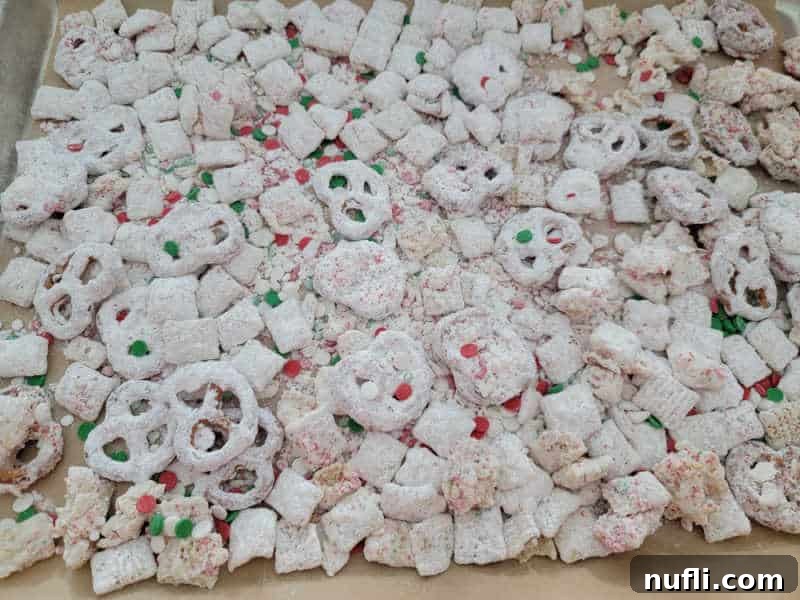 Reindeer Chow spread on a parchment-lined baking sheet