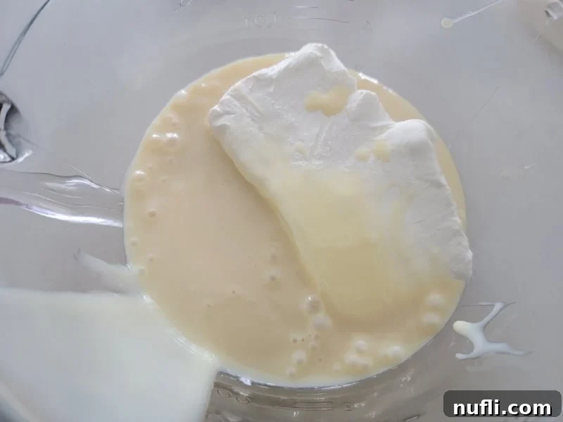 Cream cheese and sweetened condensed milk in a glass bowl for easy cherry cheesecake dip 