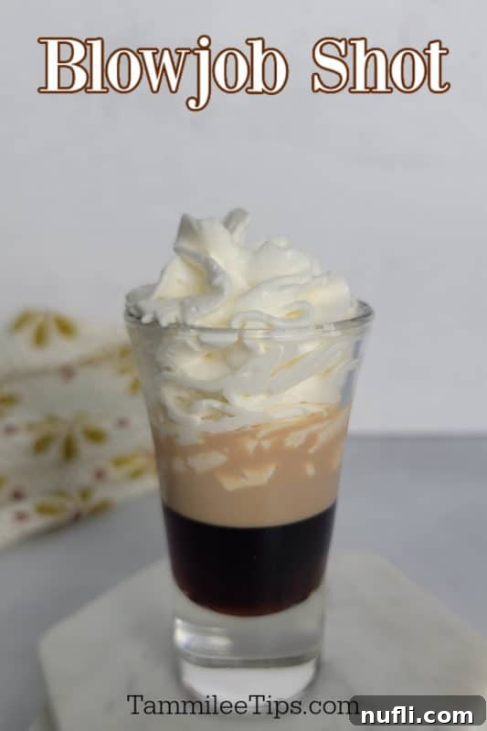 Mastering the Blowjob Shot 2 Blow Job shot text over a layered shot on a marble coaster, showcasing the distinct layers of Kahlúa, Baileys, and Amaretto.