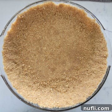 Graham cracker crust in a glass baking dish