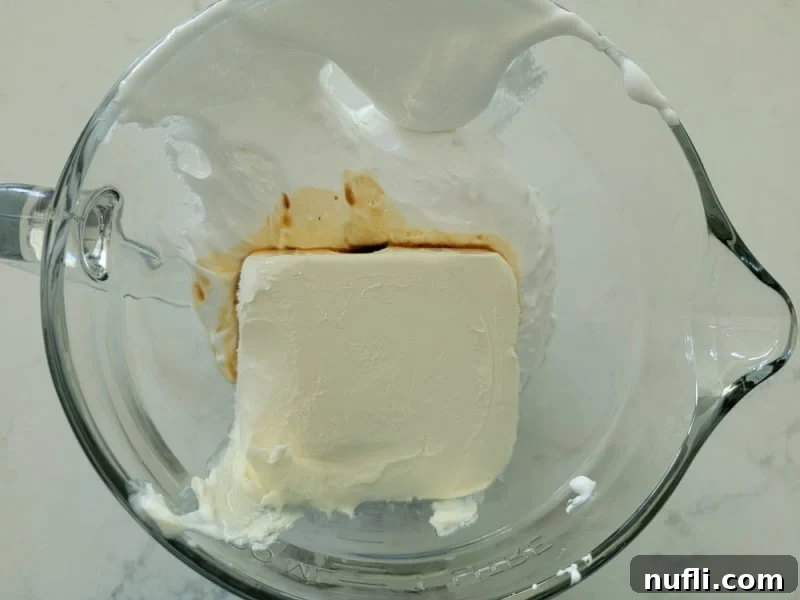 Cream cheese block and vanilla in a glass bowl for Marshmallow Fluff Fruit Dip