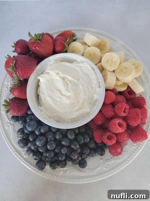 3 Ingredient Marshmallow fluff fruit dip in a white bowl surrounded by fresh fruit