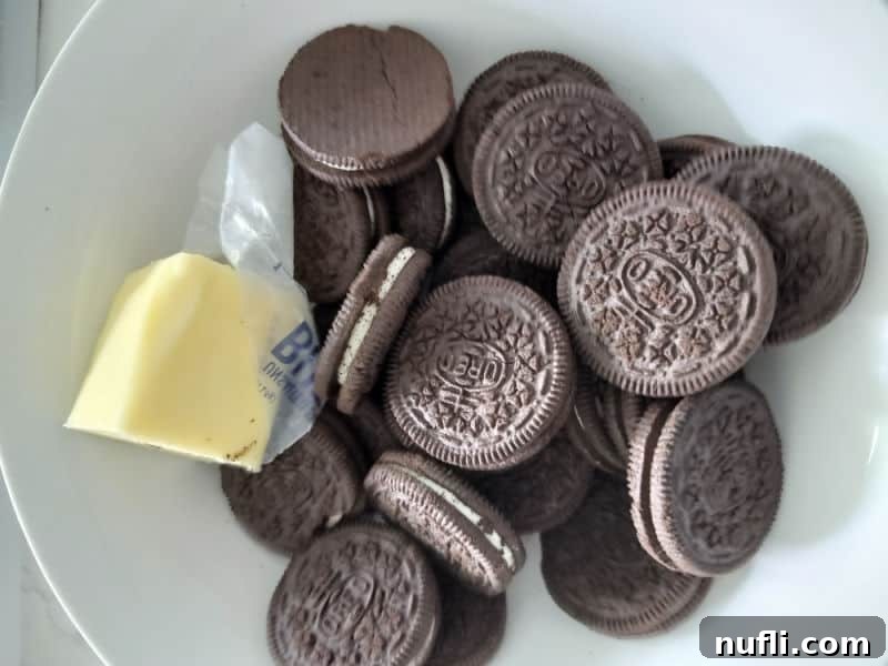 Easy Oreo Pie Crust 3 Oreo Cookies and Butter on a white plate