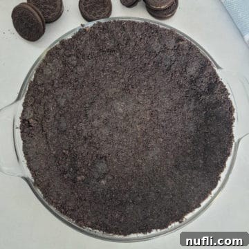 Easy Oreo Pie Crust 10 Oreo Crust in a pie dish surrounded by Oreo Cookies