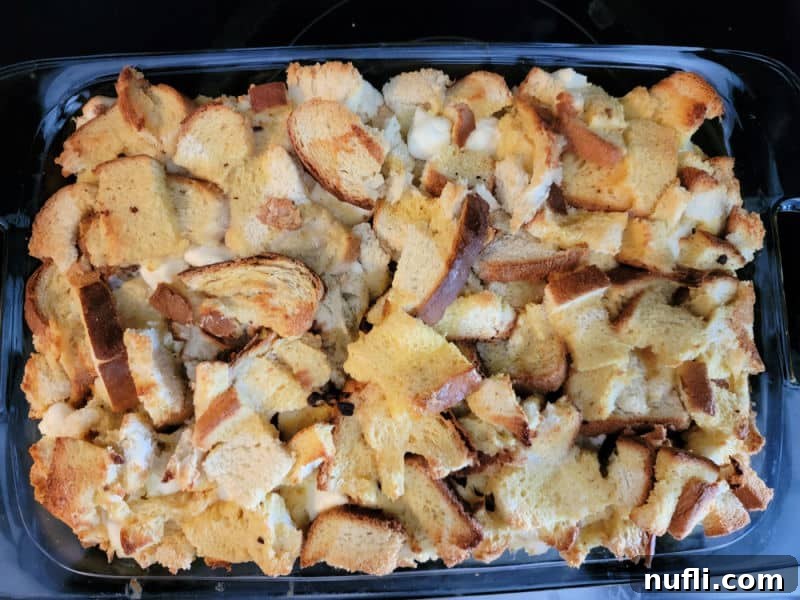 The freshly baked Overnight French Toast Breakfast Casserole, golden and bubbly, still in its glass baking dish, ready to be served.