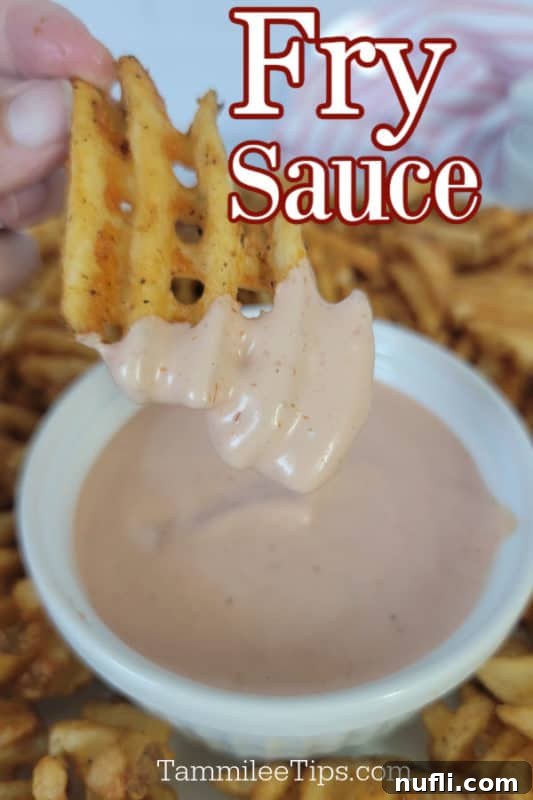 Crispy waffle fry dipping into a bowl of creamy homemade Fry Sauce