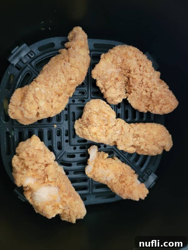 Chicken strips in an air fryer basket