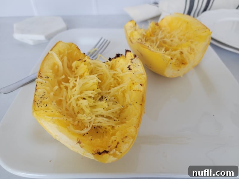 air fryer spaghetti squash next to a fork on a white plate. 