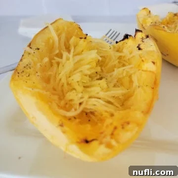 Easy Air Fryer Spaghetti Squash 9 Spaghetti squash on a white plate next to a fork
