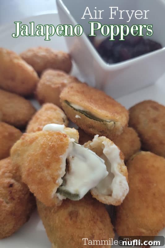 Crispy Air Fryer Frozen Jalapeno Poppers 2 Crispy Air Fryer Jalapeno Poppers on a plate, one split open to reveal melted cheese.