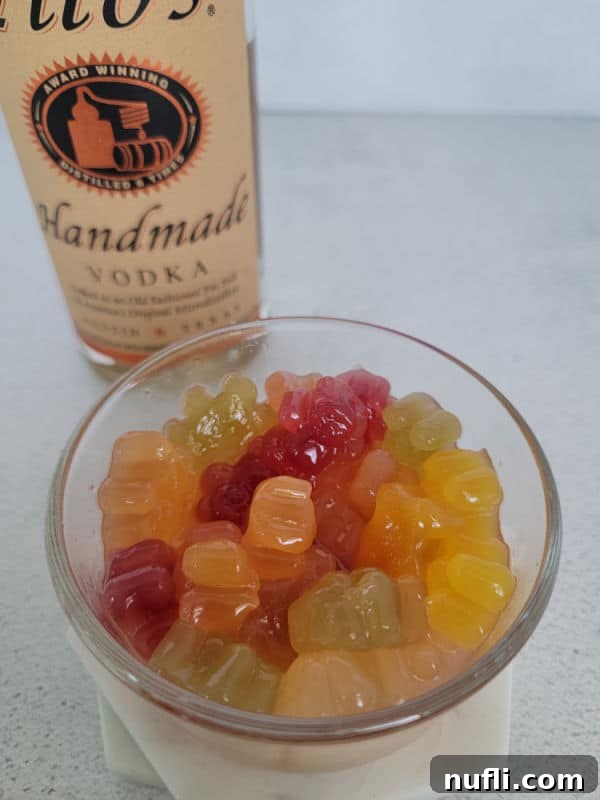 Tipsy Teddies 9 gummy bears in a glass bowl next to a bottle of Tito's Vodka