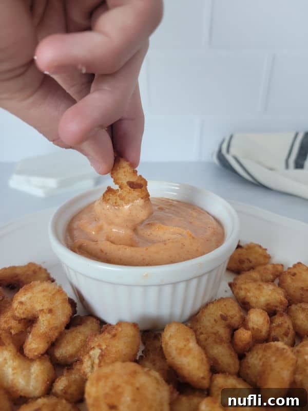 Effortless Homemade Yum Yum Sauce 7 Air fryer shrimp being dipped into a bowl of homemade Yum Yum Sauce