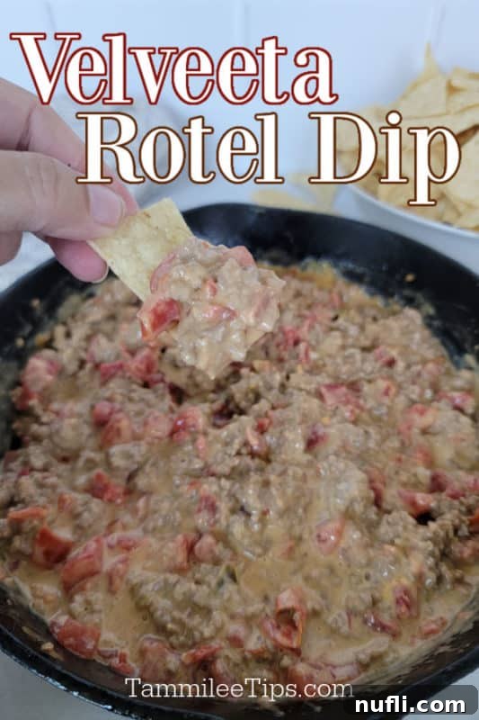 The Easiest 3-Ingredient Velveeta Rotel Ground Beef Dip 2 A tortilla chip generously loaded with Velveeta Rotel Dip, held above a cast iron skillet brimming with the warm, cheesy concoction.