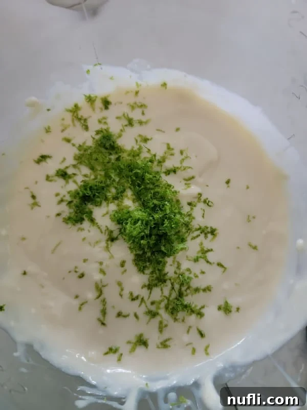 lime zest over batter in a glass mixing bowl 