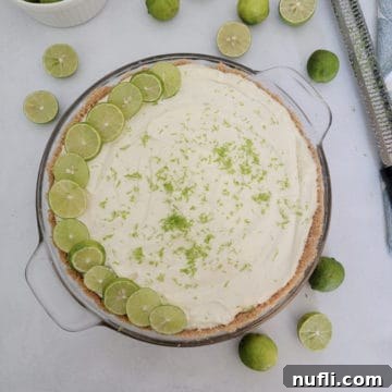 No bake key lime pie garnished with lime slices next to key limes