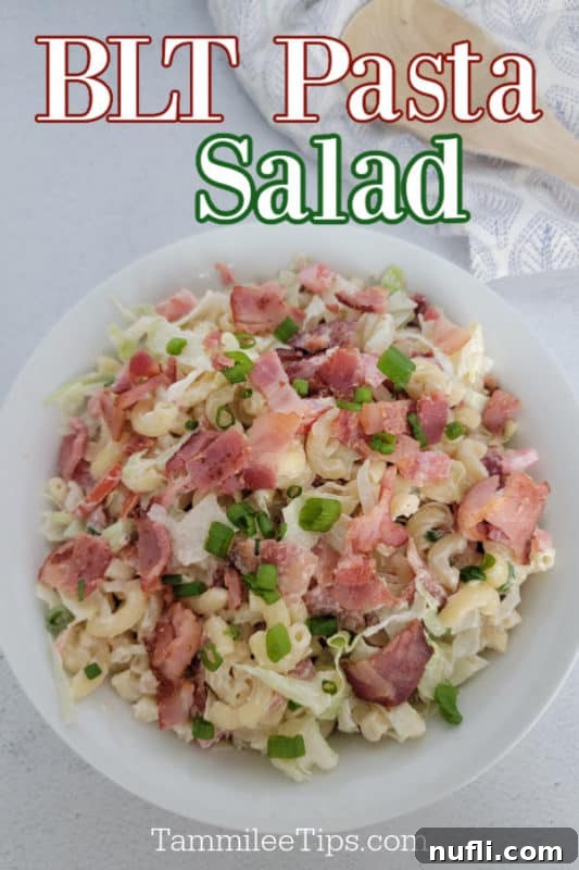 BLT Pasta Salad over a white bowl with macaroni, bacon, green onion, lettuce, and tomato
