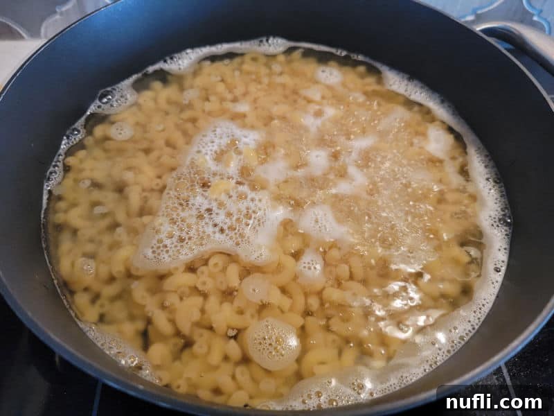 Macaroni cooking in a dark skillet on the stove top