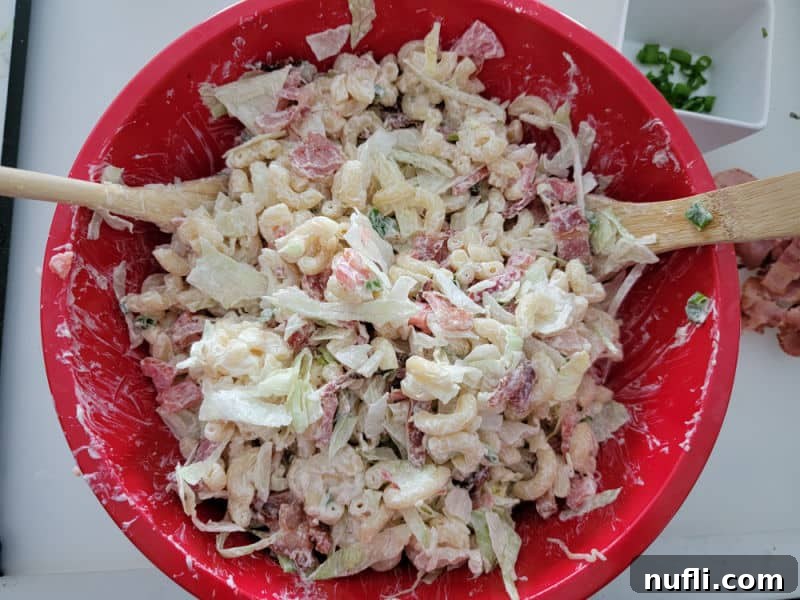 BLT Macaroni Salad in a red bowl with wooden spoons