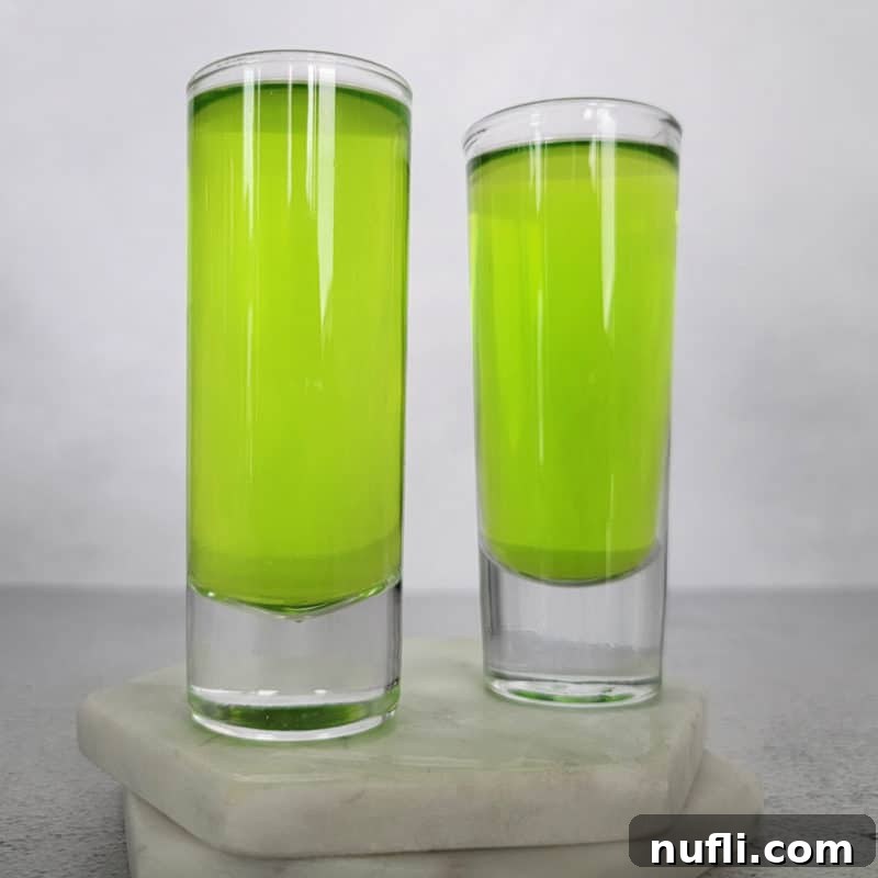 St Patrick's Day Sips & Shots 16 Two vividly bright green Ninja Turtle shots, presented on pristine white coasters, radiating a fun and vibrant energy for any festive occasion.