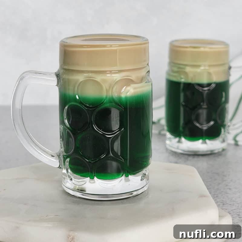 St Patrick's Day Sips & Shots 18 A charming Leprechaun Beer layered shot, resembling a miniature pint of beer, served in a tiny glass on a pristine white coaster, perfect for festive toasts.