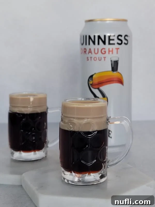 Two Baby Guinness Shots in mini beer glasses next to a can of Guinness, highlighting the visual mimicry.